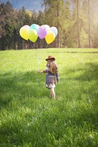 Girl in a field with ballons